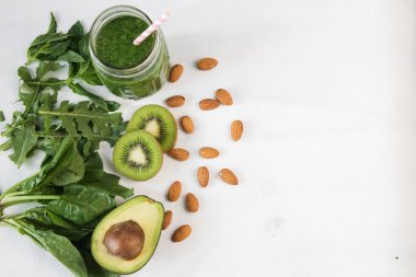 Cam üst görünümden Beyaz ahşap zemin üzerine yeşil sebze güler yüzlü