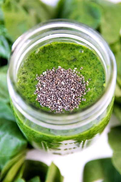 Green smoothie in jar with chia, overhead on glass, healthy drink with vegetable leaves of spinach