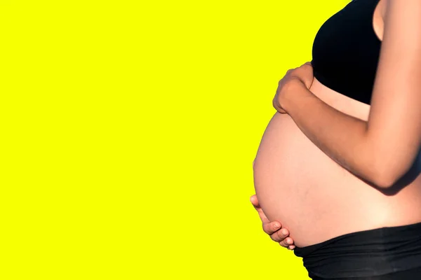 Vientre Mujer Embarazada Con Las Manos Fondo Amarillo — Foto de Stock