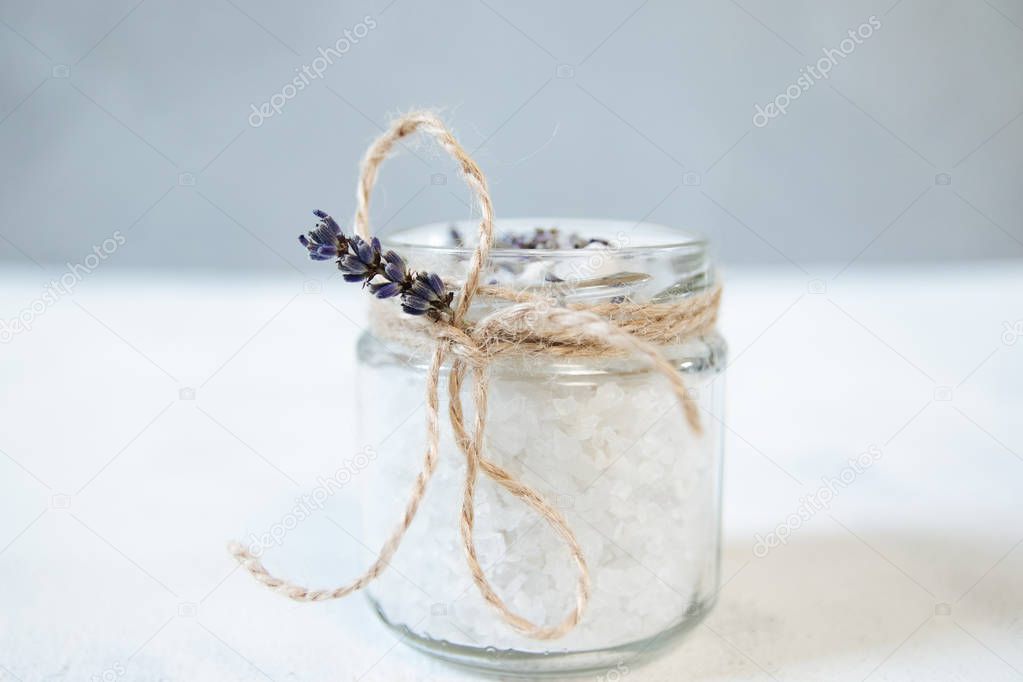 Natural herbal sea salt with aromatic lavender - perfect for relaxation. Cosmetic jars and bottles with salt, lavender flowers