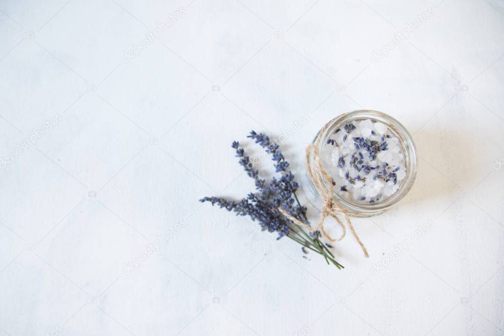 Natural herbal sea salt with aromatic lavender - perfect for relaxation. Cosmetic jars and bottles with salt, lavender flowers
