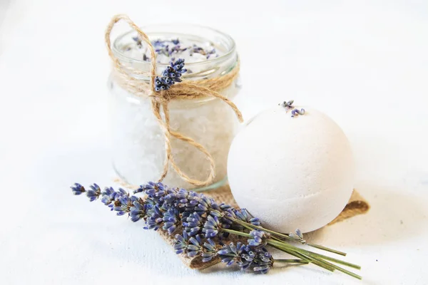 Natural herbal sea salt with aromatic lavender - perfect for relaxation. Cosmetic jars and bottles with salt, lavender flowers, bath bomb — Stock Photo, Image