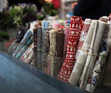 Karton kutunun içindeki bir iple bağlanmış renkli giysilerin ruloları.