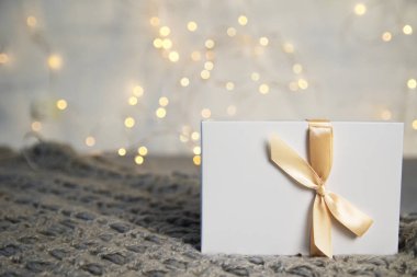 Noel hediyeleri ile ışık şerit ışık arka plan üzerinde beyaz kutusunda. Yeni yıl tatil kompozisyon afiş. Metniniz için kopya alanı