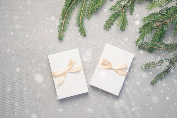 Two Christmas Gift in White Box with light Ribbon on grey Background. New Year Holiday Composition Banner. Copy Space For Your Text