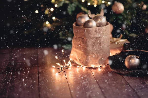 Рождественская сумка с шариками и огнями на темной доске, новогодняя концепция — стоковое фото