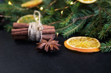 Noel ağacı çam dalları Kuru portakal ile. karanlık bir arka plan üzerine tarçın, anason.