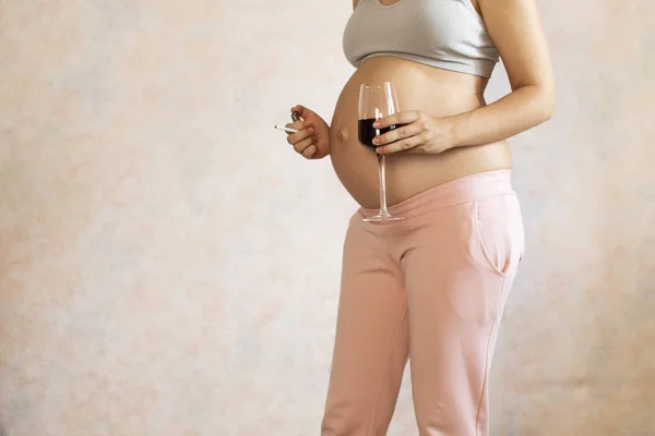 Donna incinta con bicchiere di vino rosso in mano al chiuso — Foto Stock