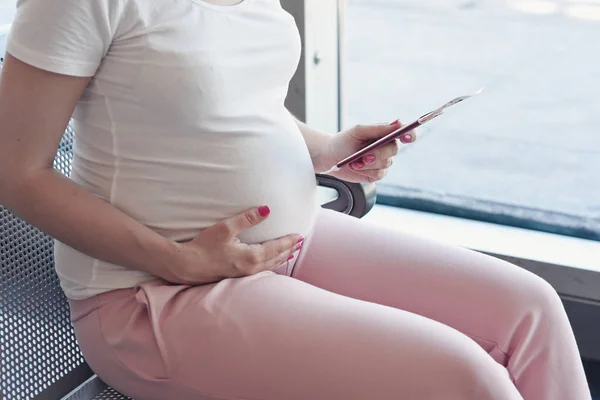 Gravid kvinna resor med flyg sitter på säte. — Stockfoto