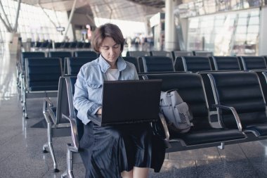 dizüstü bilgisayar kullanan airport adlı genç bir kadın