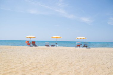Üç şemsiyeleri ve sandalyeler Durres, Arnavutluk Adriyatik Denizi kıyısında kumlu plajda