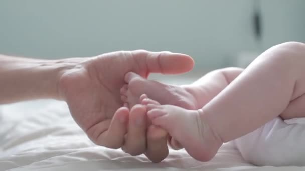 Батько зворушливо і вважаючи його новонародженого Babys маленькі пальці. Крупним планом. Батьківський Холдинг новонароджених ніг. Щасливого батьківства. — стокове відео