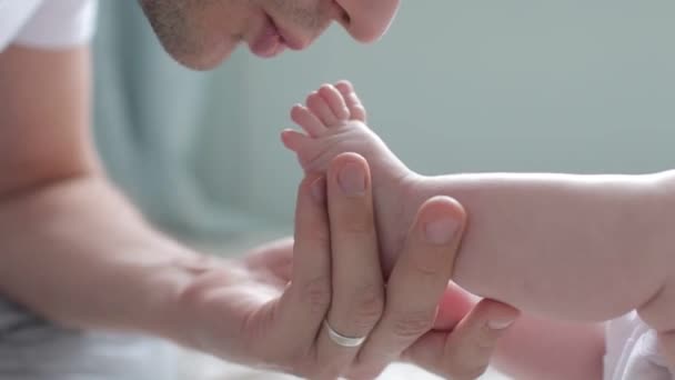 Close up tiro de pai beijando pés de bebê — Vídeo de Stock