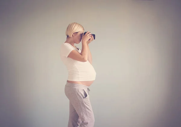 Femme enceinte photographe avec une caméra de film — Photo