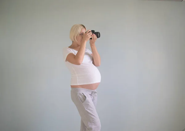 Hamile kadın fotoğrafçı bir film kamerası ile — Stok fotoğraf