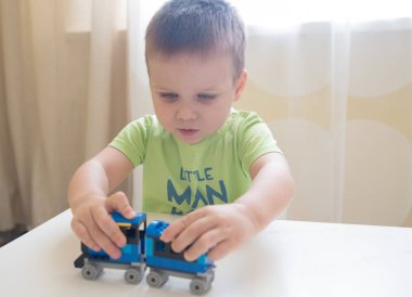 Oğlum renkli tuğlalar ile yapılan Oluşturucu tren ile oynamak portre kadar kapatın