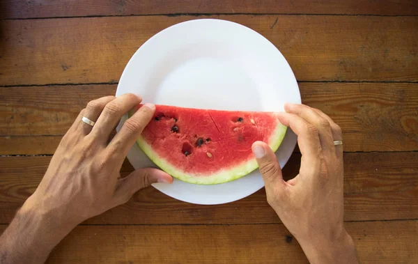 Plátek vodního melounu v mans hand, zblizka — Stock fotografie