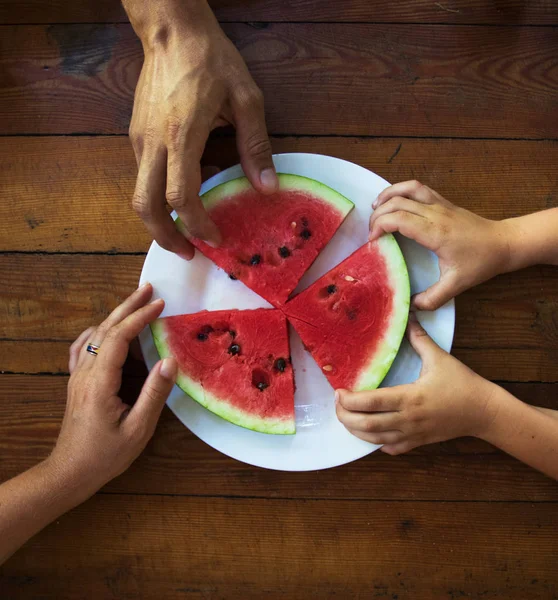 Plátek vodního melounu v mans, Dámská a dětská ruka, zblizka — Stock fotografie