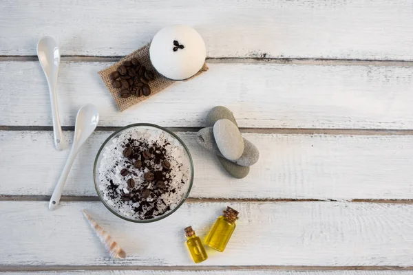 Ароматерапия и спа концепция. Курортная соль с ароматом кофе возле мыла, спа-масла и мочалки на белом фоне — стоковое фото