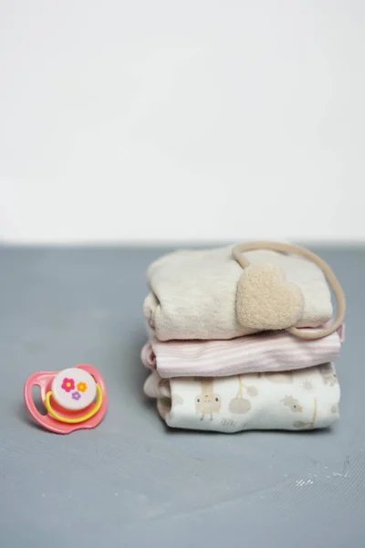 Στοίβα διπλωμένο ρούχα πολύχρωμο βαμβακερό σε λευκό τραπέζι κενό φόντο, μωρό πλυντηρίου. — Φωτογραφία Αρχείου