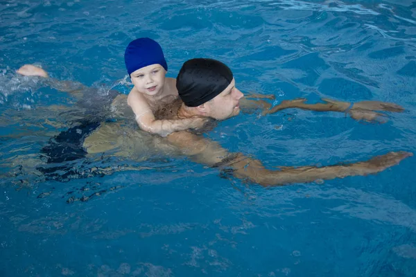 Pai ensinando filho a nadar na piscina. Divertindo-se com papai — Fotografia de Stock