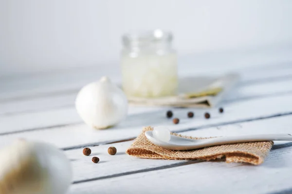 Pot en verre d'oignons marinés sur fond de bois blanc — Photo