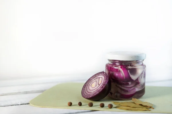 Glass Jar of Pickled Onions on White wood Background