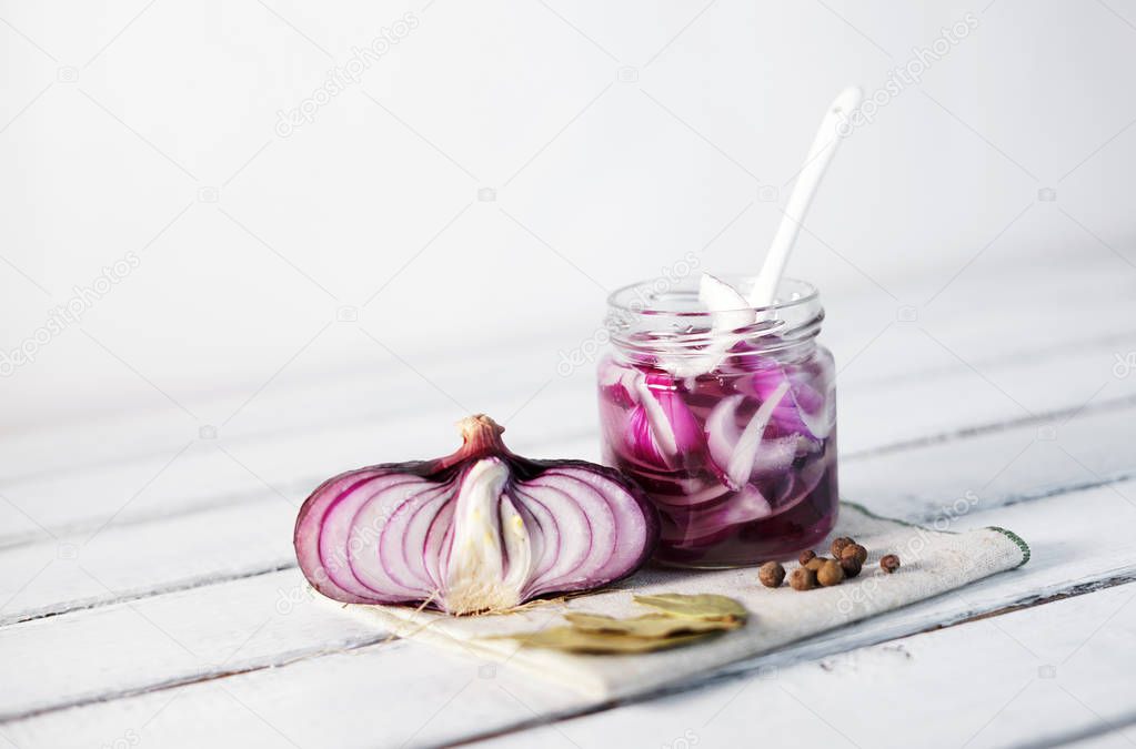 Glass Jar of Pickled Onions on White wood Background