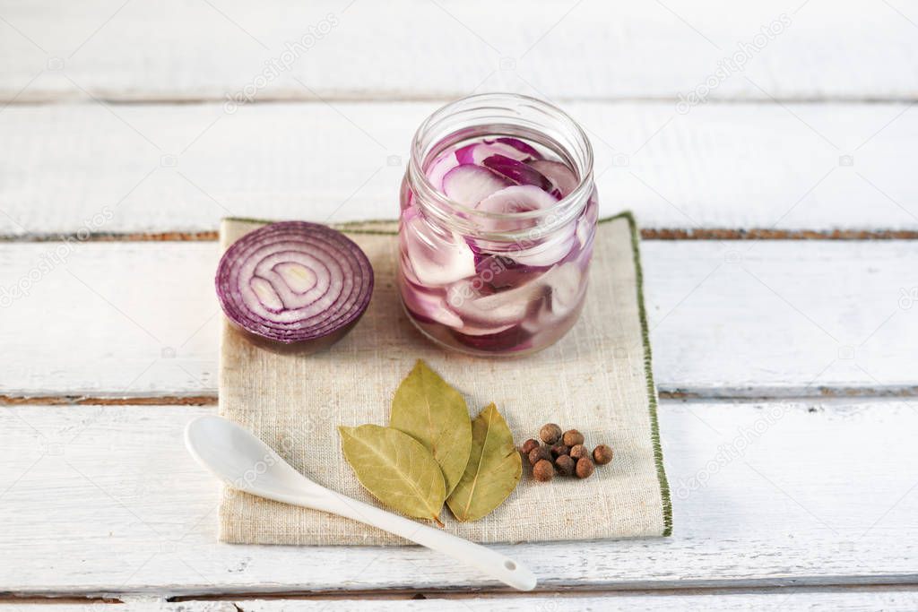 Glass Jar of Pickled Onions on White wood Background