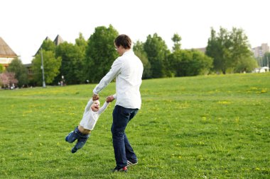 Baba açık elele çocuk döner. Aile. Baba oğlu iplik. Mutlu komik insanlar. Yaz. Duygular. Çocukluk