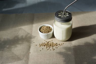 bir cam kavanozda kenevir tohumu vegan taze süt, temiz yeme, sigara süt. Ketenden arka krep