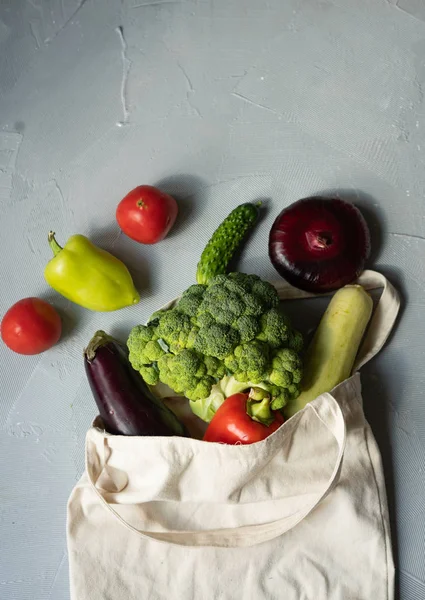 Set of products in a cotton eco bag on a marble table, eggplant, broccoli, tomatoes, peppers, zucchini. The concept of zero waste. — Stock Photo, Image