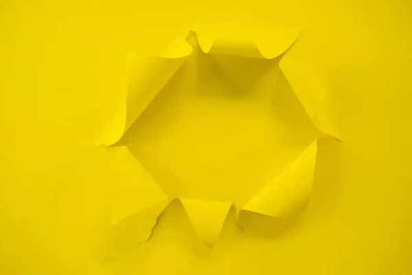 Papel amarillo rasgado sobre un fondo amarillo — Foto de Stock