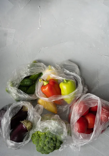 一次性塑料包装问题。塑料袋中的蔬菜。零浪费概念 图库图片