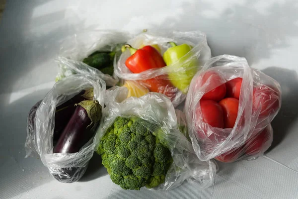 一次性塑料包装问题。塑料袋中的蔬菜。零浪费概念 免版税图库图片