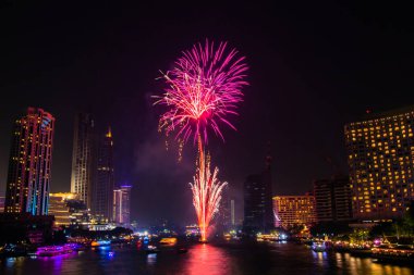 Kutlama festivali için gece şehir manzarası arka planında havai fişekler.
