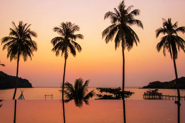 Puesta de sol que refleja en la superficie del agua en primer plano con árboles de coco área ao bang bao en la isla de Koh Kood es un distrito de la provincia de Trat . — Foto de Stock