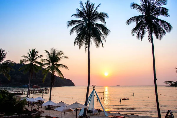 Puesta de sol que refleja en la superficie del agua en primer plano con árboles de coco área ao bang bao en la isla de Koh Kood es un distrito de la provincia de Trat . — Foto de Stock