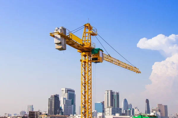 Daru használják az építőiparban a magas épületek szerszám nagy ipar a kék ég és fehér felhők. — Stock Fotó