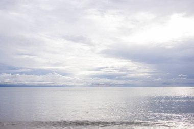 Durgun denizin üzerinde yağmur durduktan sonra gri gökyüzü