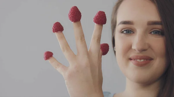年轻的白种女人直长头发吃树莓从手指 — 图库照片