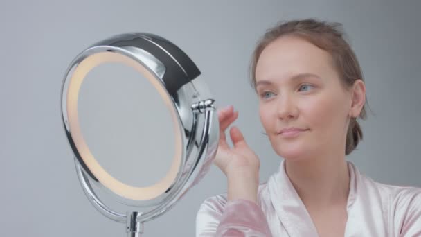 Kaukaski kobiece kobieta lustro z pierścieniem światła z nie wyglądający makijaż zbadać jej skórę i sprawia, że zabieg na twarz — Wideo stockowe