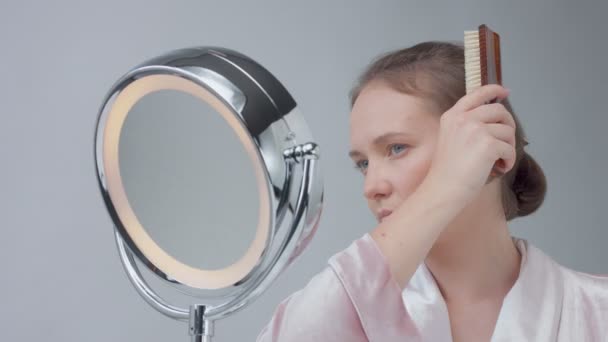 Mujer caucásica con espejo con anillo de luz sin maquillaje mirada examinar su piel y hace tratamiento facial — Vídeos de Stock