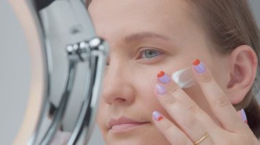 kadın bir krem yanağına koy ve bir masaj yapar