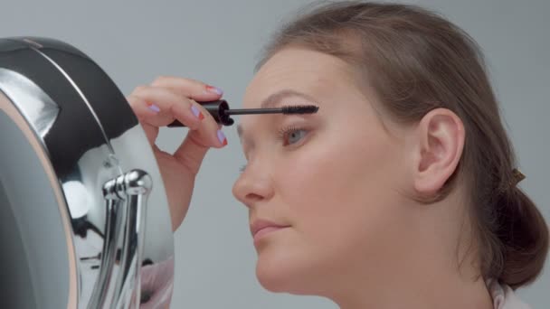 Mujer caucásica con espejo con anillo de luz sin maquillaje mirada examinar su piel y hace tratamiento facial — Vídeo de stock
