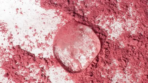 Melting cube of ice onn pink makeup powder — Stock Video