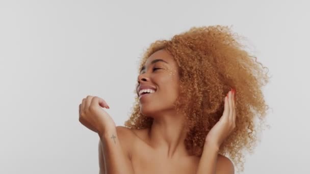 Mujer de raza mixta con gran pelo rubio afro rizado en el estudio — Vídeo de stock