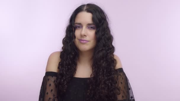 Pelo rizado negro modelo de talla grande con ojos marrones sobre fondo lila con maquillaje lila — Vídeos de Stock