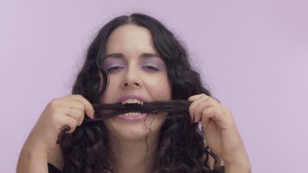 Черный вьющиеся волосы плюс размер модели с коричневыми глазами на сиреневом фоне с лиловым макияжем — стоковое видео