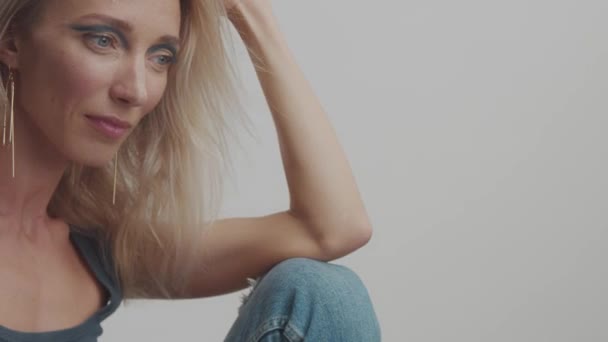 Blonde 30s vrouw poses in studio naar de camera — Stockvideo